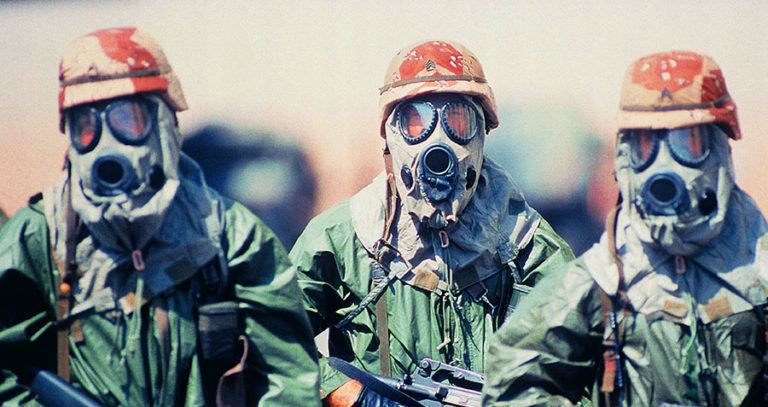 Troop Of Soldiers In Camouflage Uniforms, Helmets And Gas Masks