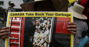 Protester Holds Up Sign Against Canadian Trash