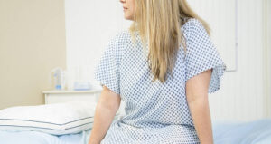 Woman Looks Off In Hospital Gown