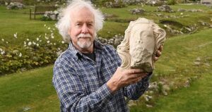 Man Holding Stone Head
