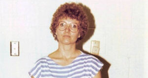 Candy Montgomery Standing Against White Wall